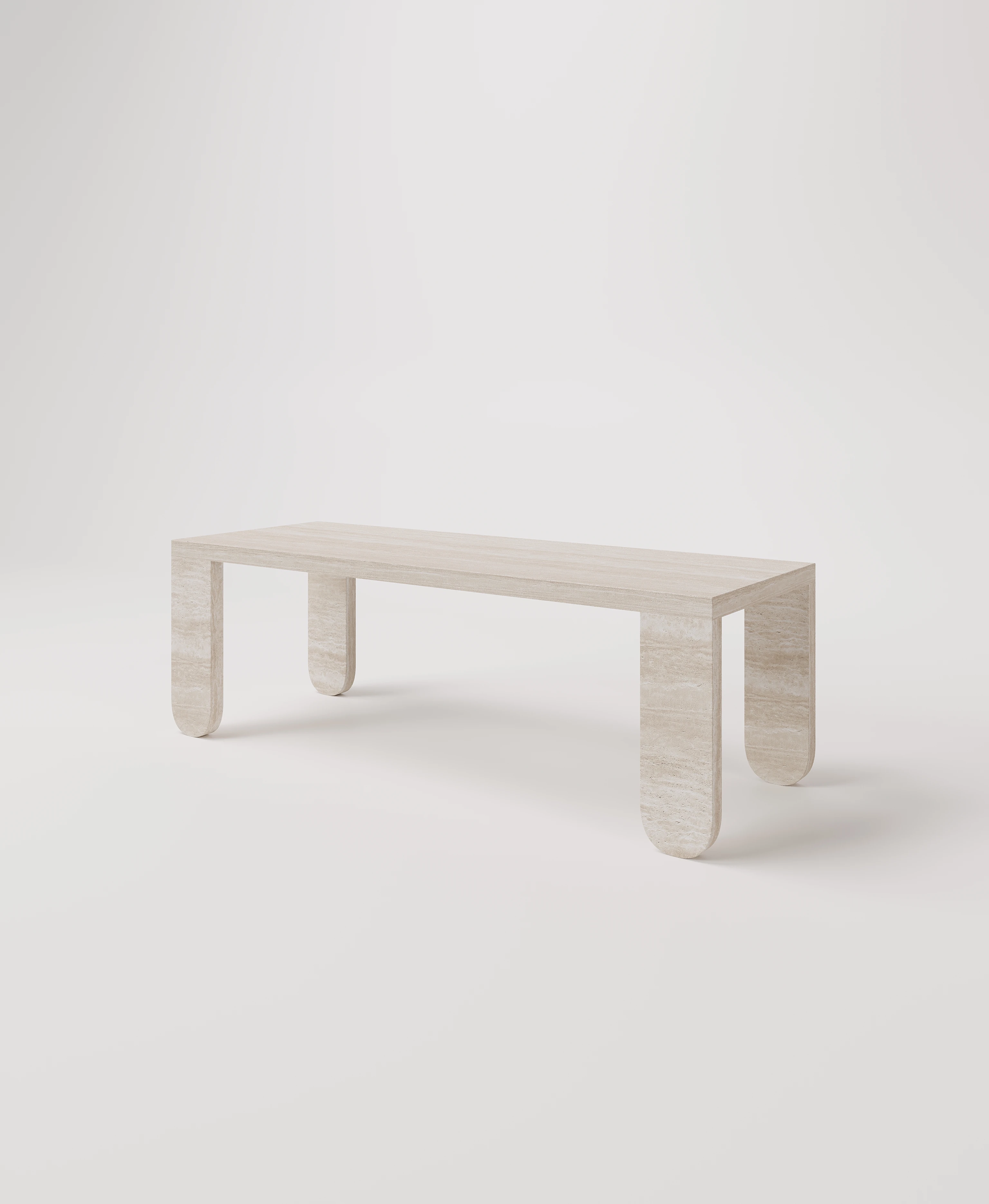 Большой стол с закругленными ножками из светлого травертина.