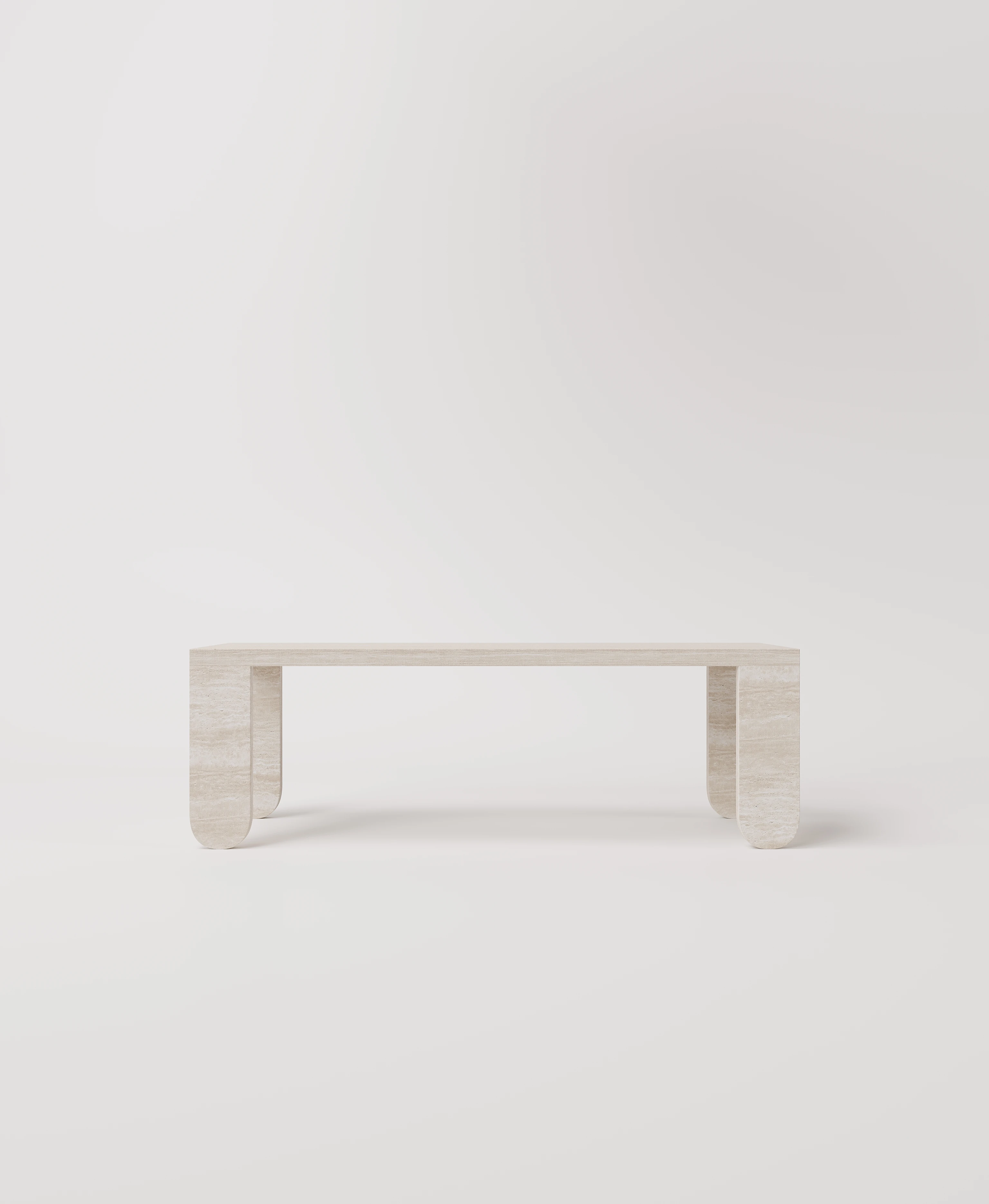 Большой стол с закругленными ножками из светлого травертина.