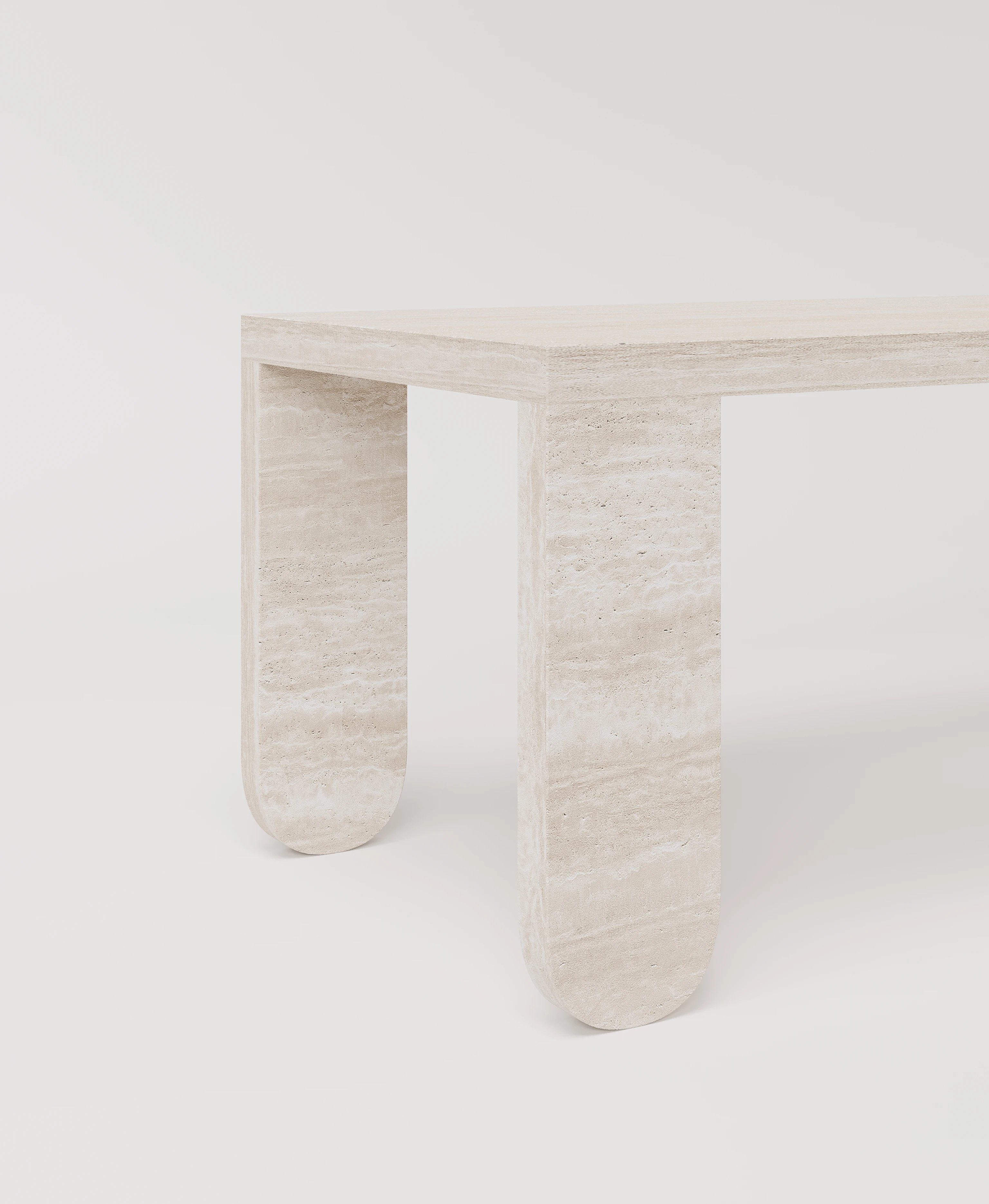 Большой стол с закругленными ножками из светлого травертина.